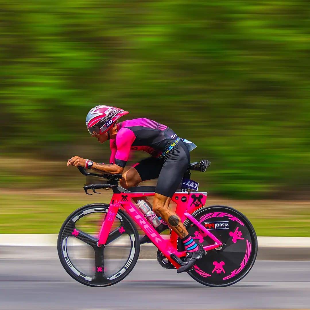 Atleta de triatlo em bicicleta Trek rosa em alta velocidade